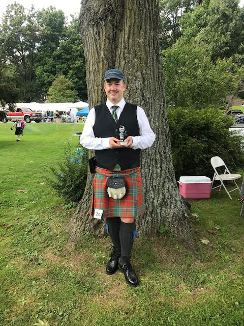 NYC Bagpipes piper holding Covenanter Highland Games Trophy